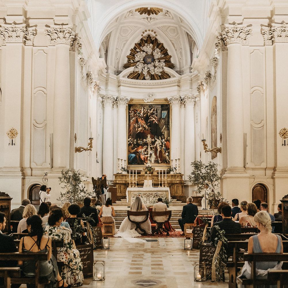 The bride and groom bow their heads as they get married at a Tuscany church