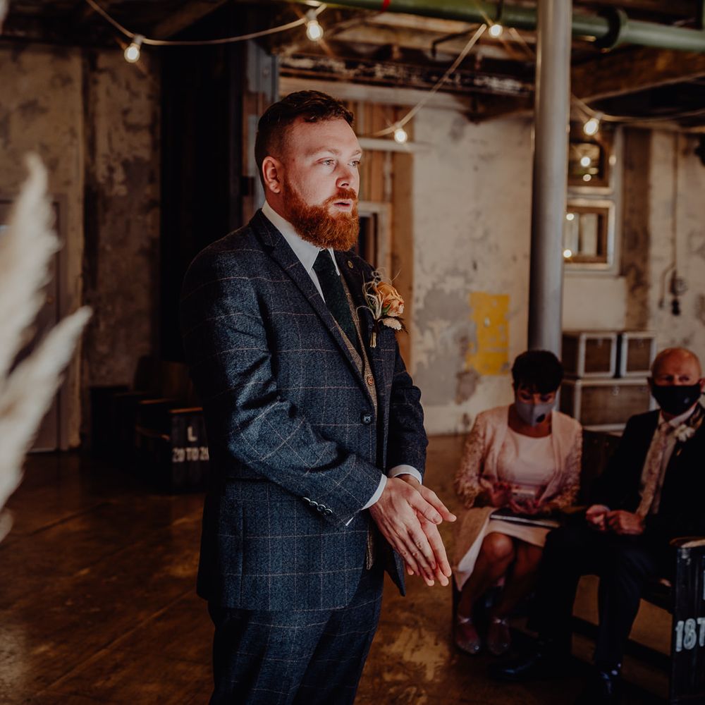 Groom waiting at the altar in a blue wool suit