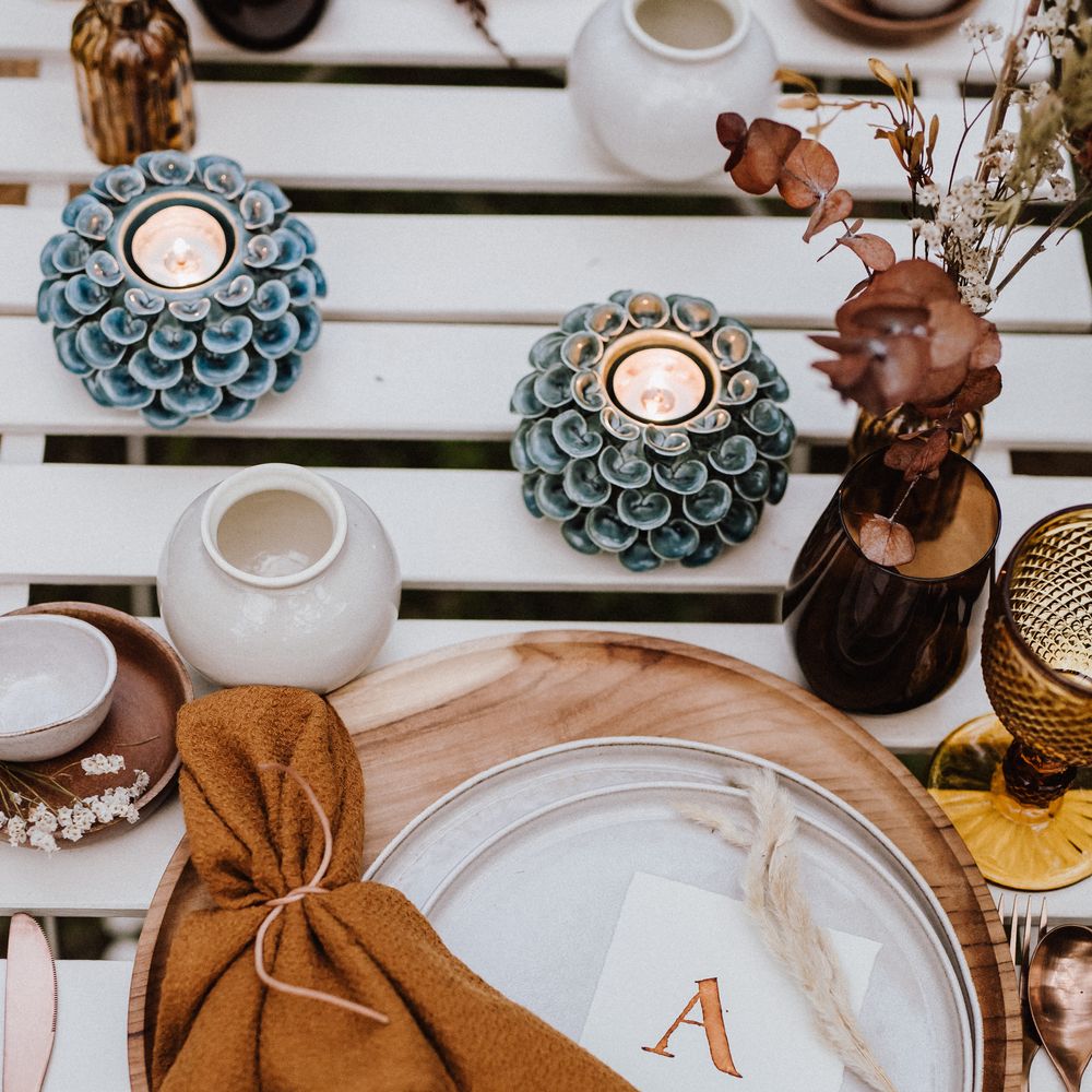 White plates atop wooden placemats with burnt orange napkin 