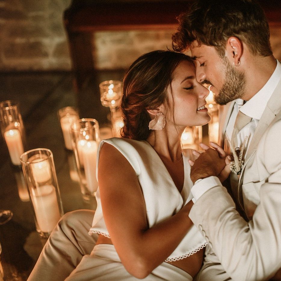 Intimate wedding portrait of a bearded groom in a beige suit holding his brides hand in separates