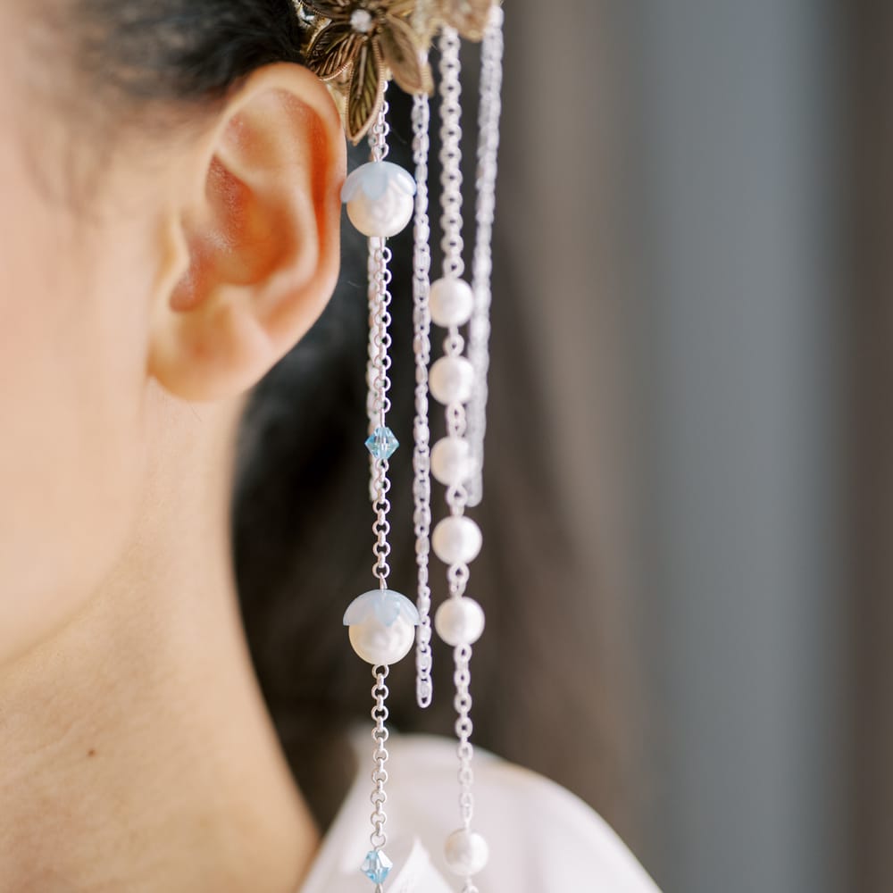 Pearls on chains fall from golden embroidered bridal crown