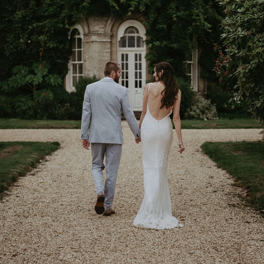 Low back wedding dress and blue wedding suit