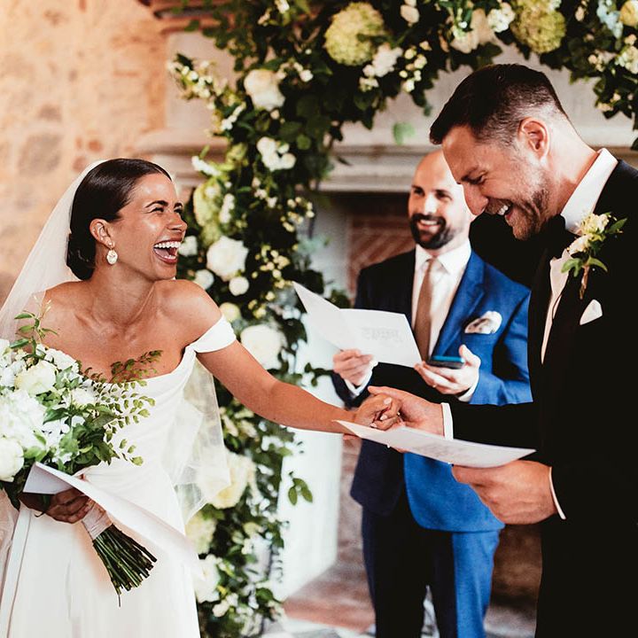 Bride & groom laugh with one another during ceremony on their wedding day