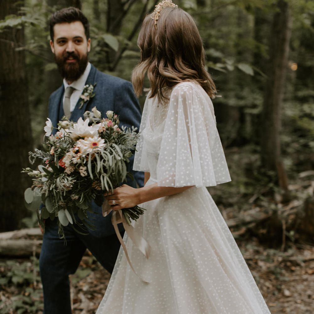 Bride walks whilst her E&W Couture wedding gown trails around her