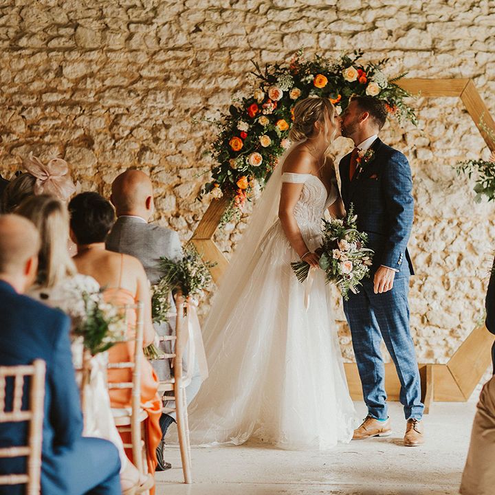 Bride and groom at East Afton Farmhouse wedding with orange flower decor