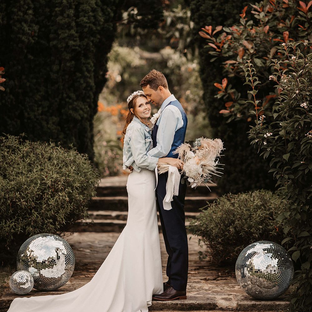 Bride & groom kiss on staircase outdoors on their wedding day