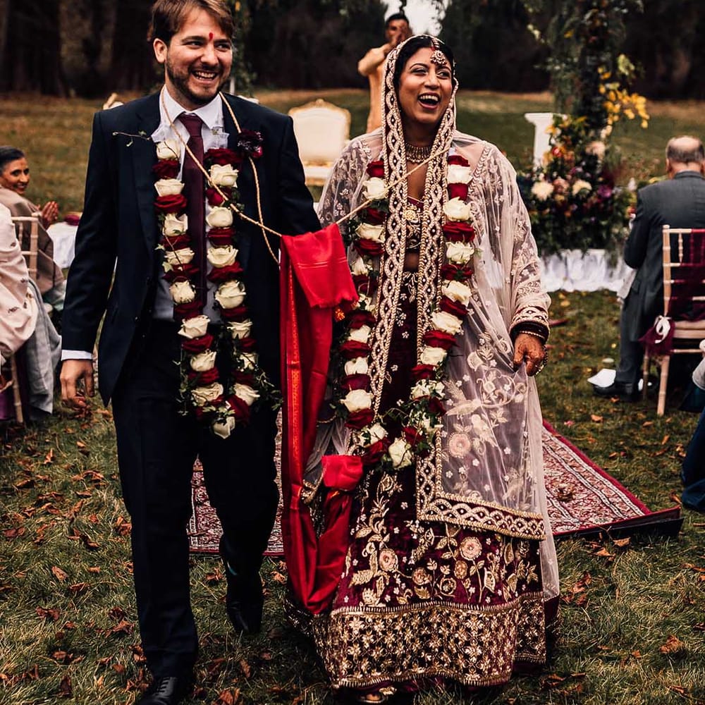 Indian wedding at Minley Manor Bride & Groom smile hand in hand