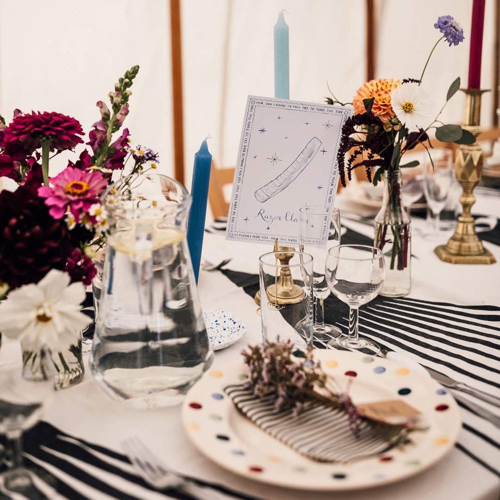 Colourful wedding tablescape with pops of blue, yellow and stripes and DIY table numbers