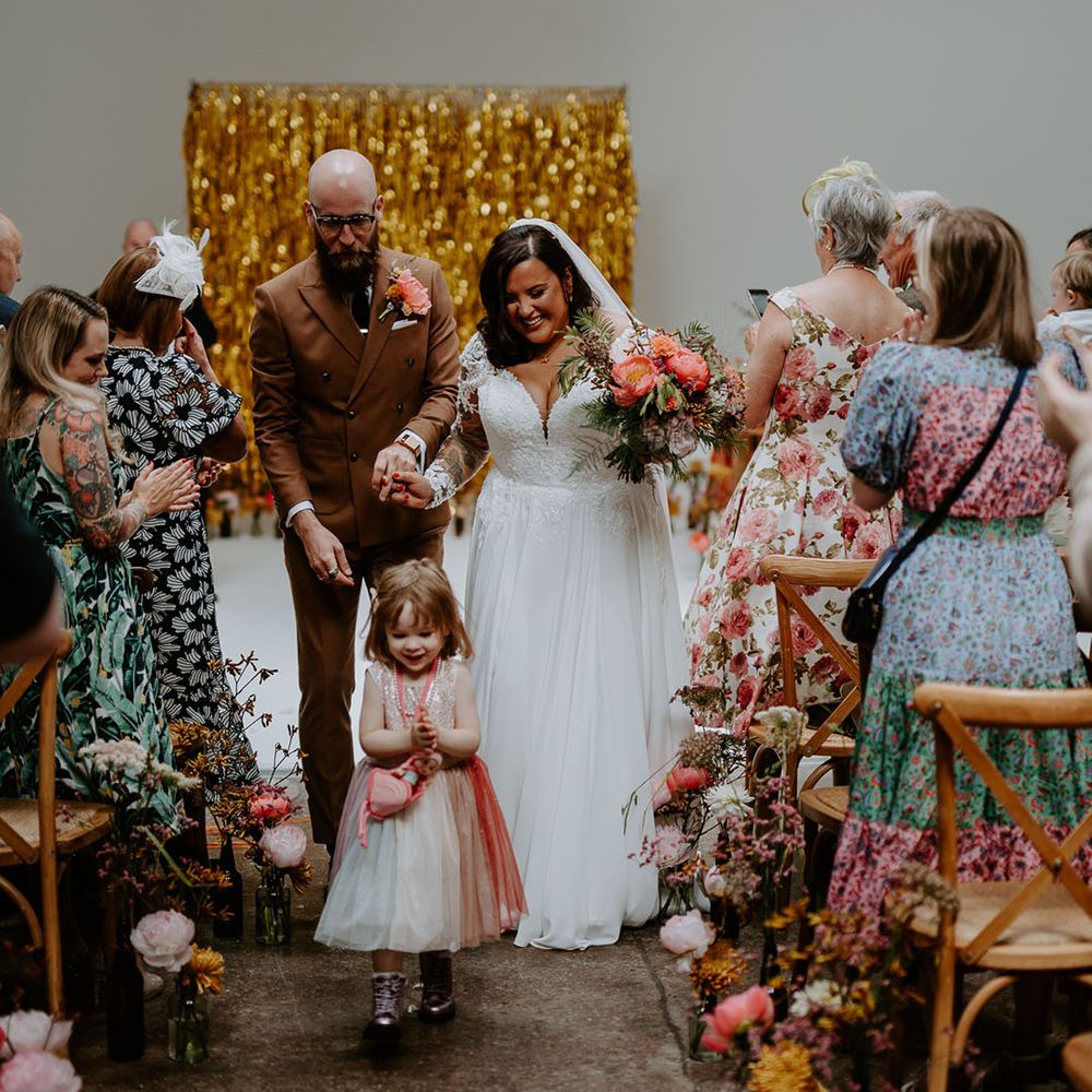 Bride & groom walk down the aisle during industrial styled wedding ceremony 