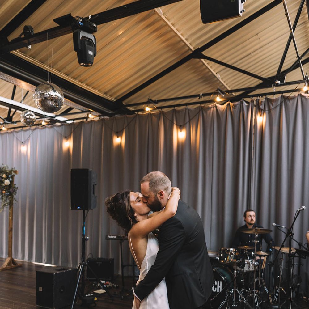 The bride and groom have their first dance in front of the live wedding band 