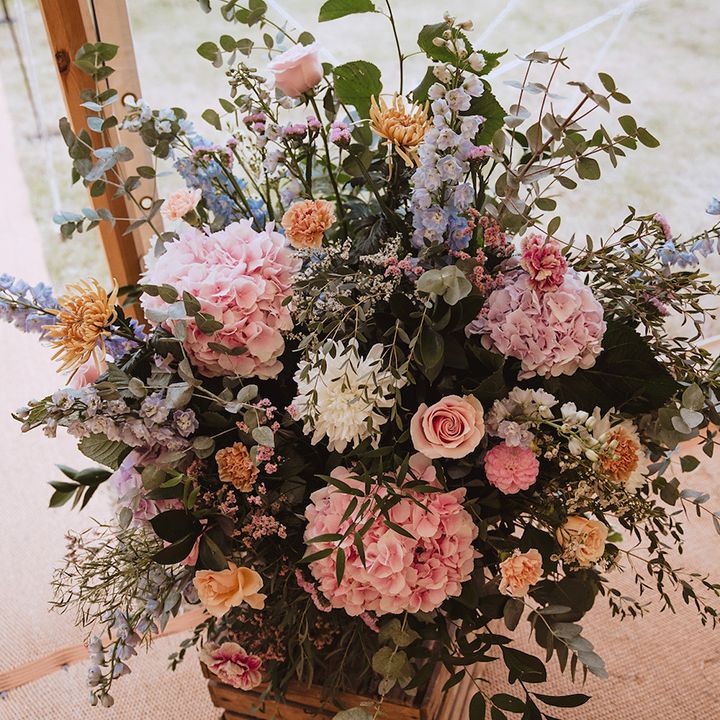Pastel pink, blue and yellow wedding flower arrangements 