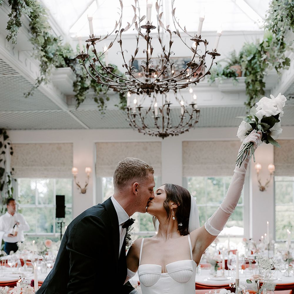 Bride in Aleena Lena wedding dress kissing the groom at their black tie wedding 