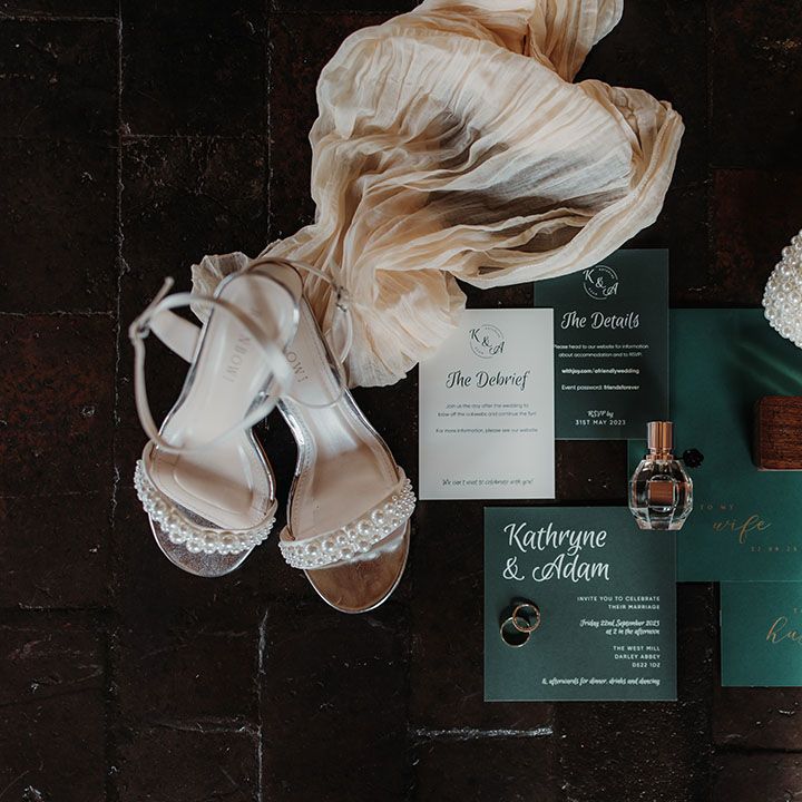 Green wedding stationery suite with pearl bridal accessories and perfumes 