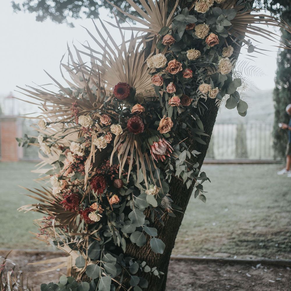 King protea, dried palm leaves and foliage flower arrangement 
