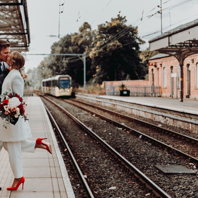 Bride and groom kissing at the tram station for Manchester micro wedding 