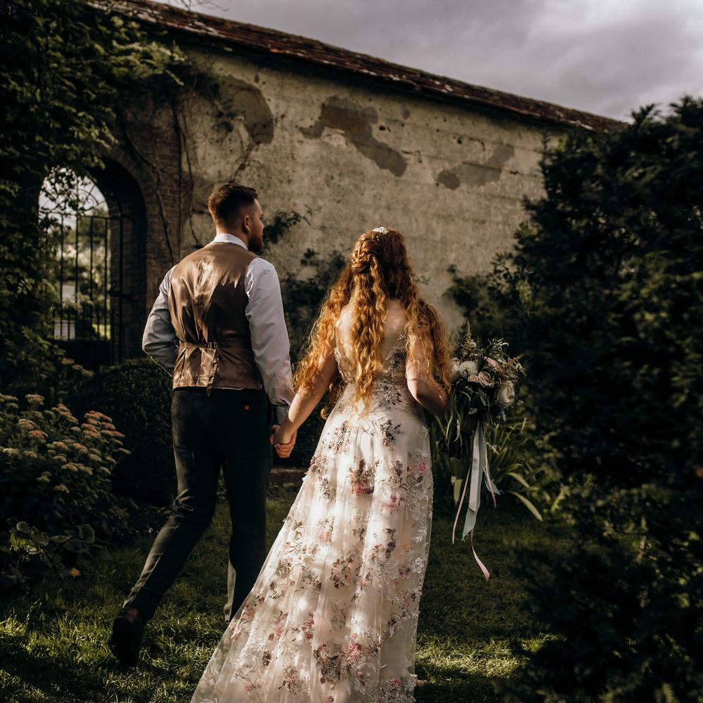 Bride & groom walking through Houghton Lodge Gardens 