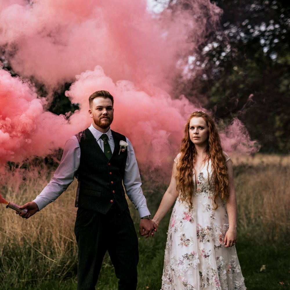 Bride & groom use pink smoke bombs for post wedding pictures 