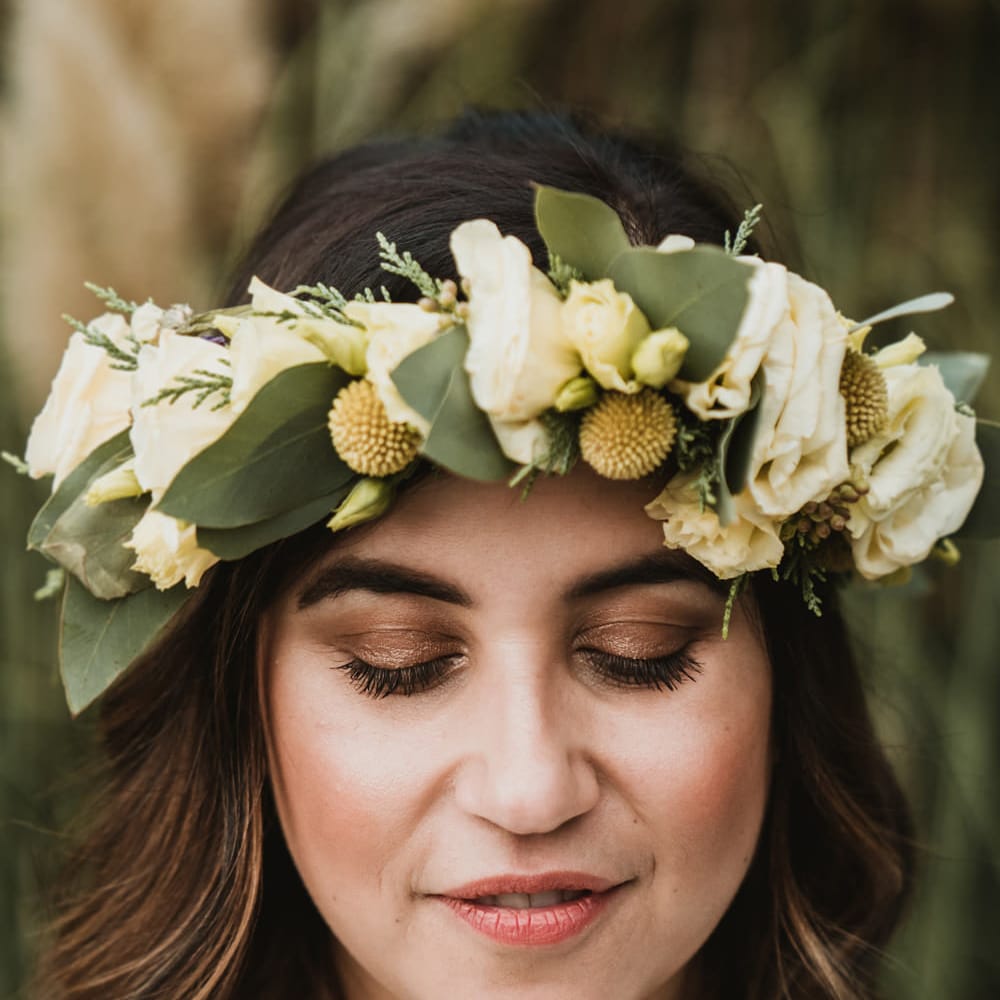 Brown shimmering eyeshadow for boho bride in a flower crown with white flowers, foliage and yellow Billy Buttons 