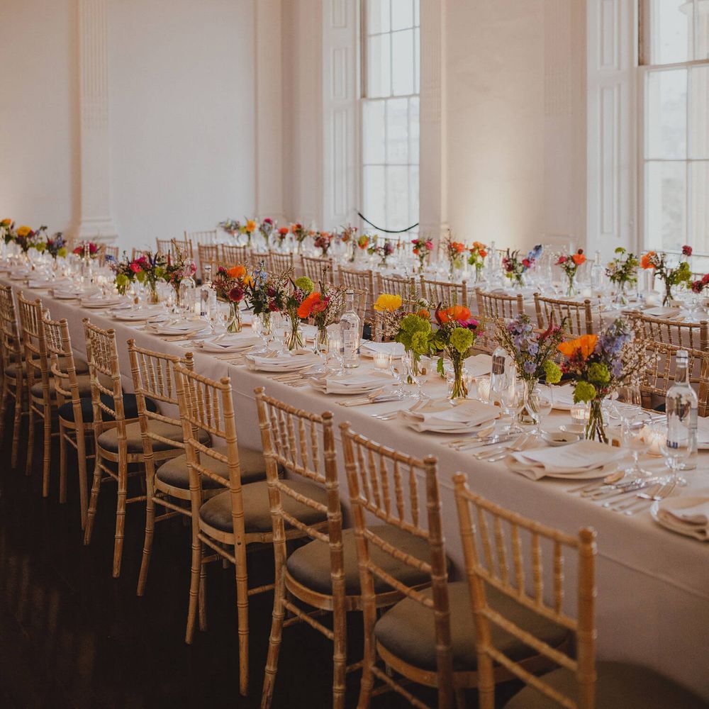 Bright wedding flowers in bud vases for wedding banquet tablescape