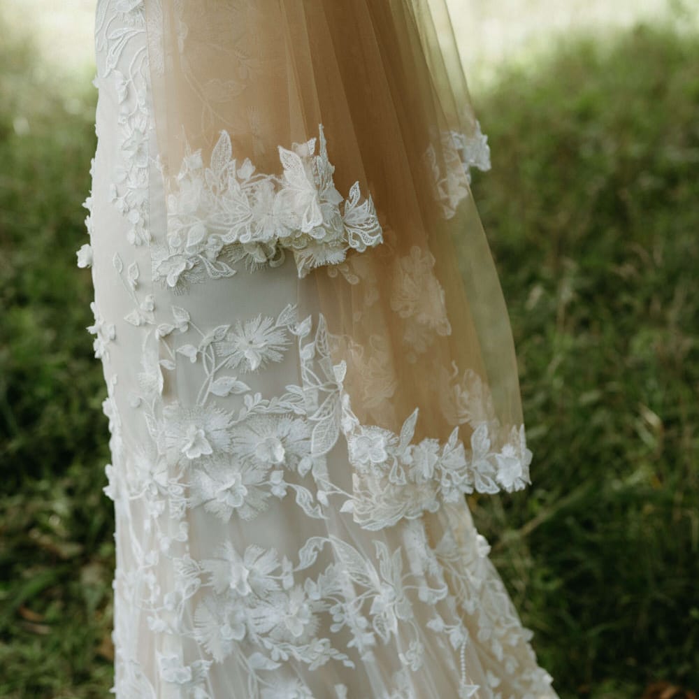 Floral embroidered wedding dress with matching tulle bridal cape for boho wedding at Berwick Lodge