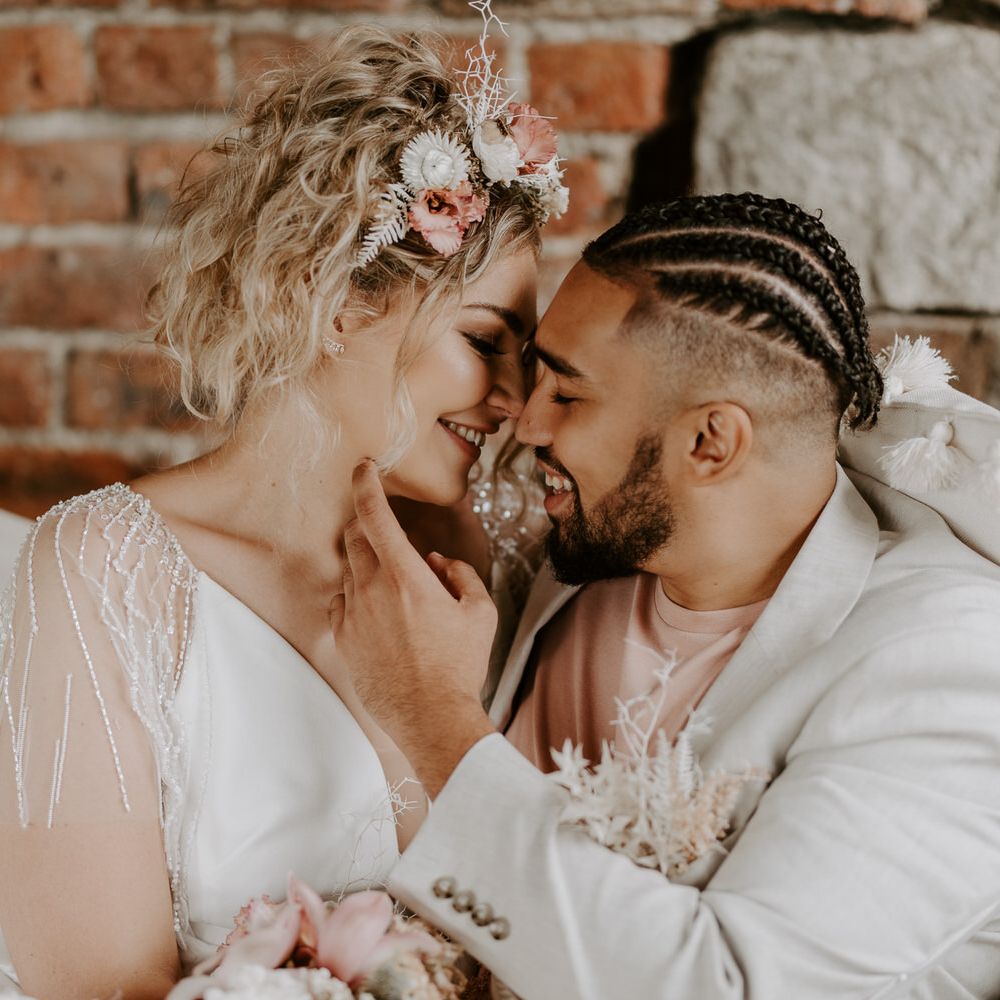 Bride and groom together on a hammock, the bride has tropical pink shells and florals as a headband