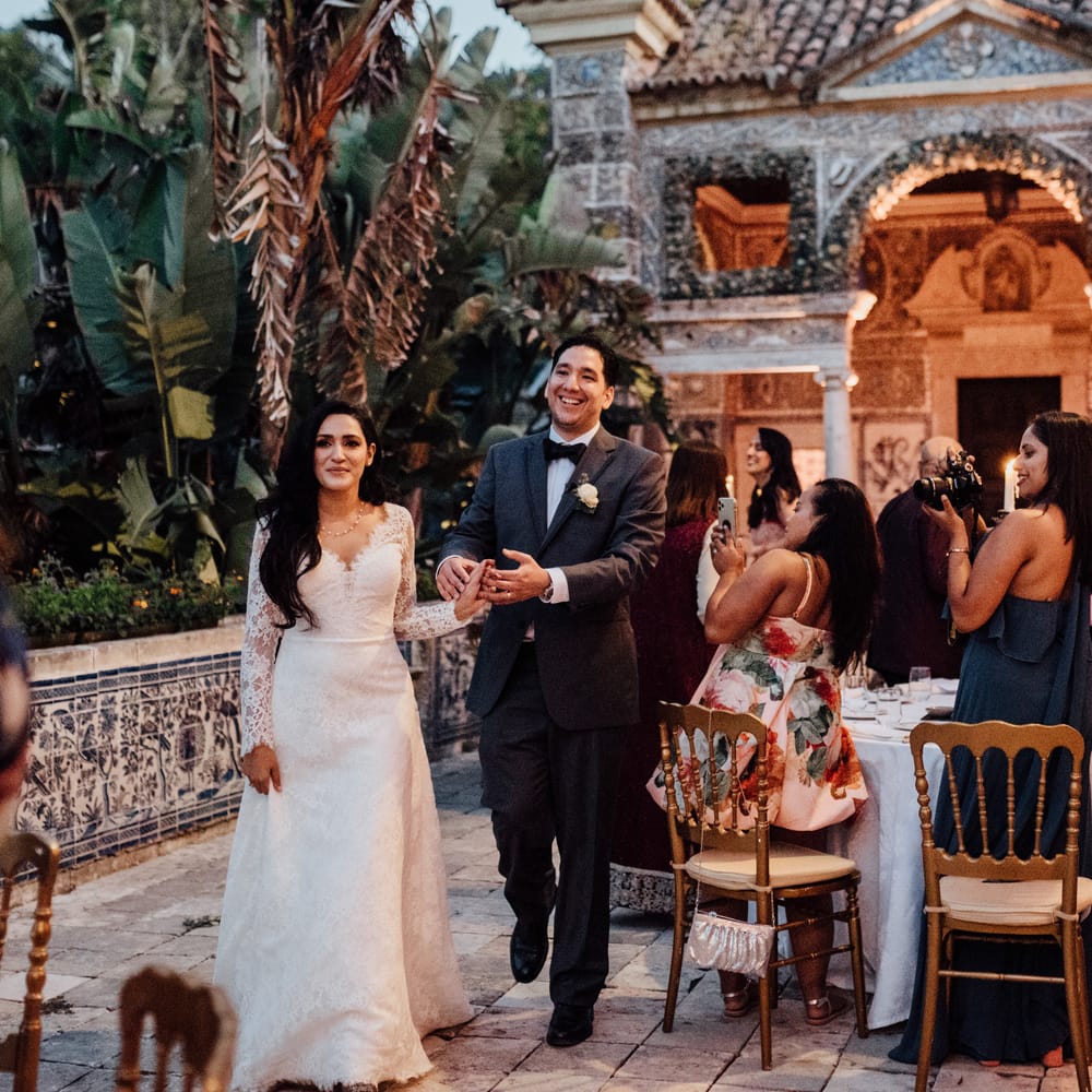 Bride & groom walk into wedding reception in Lisbon as light glows around them