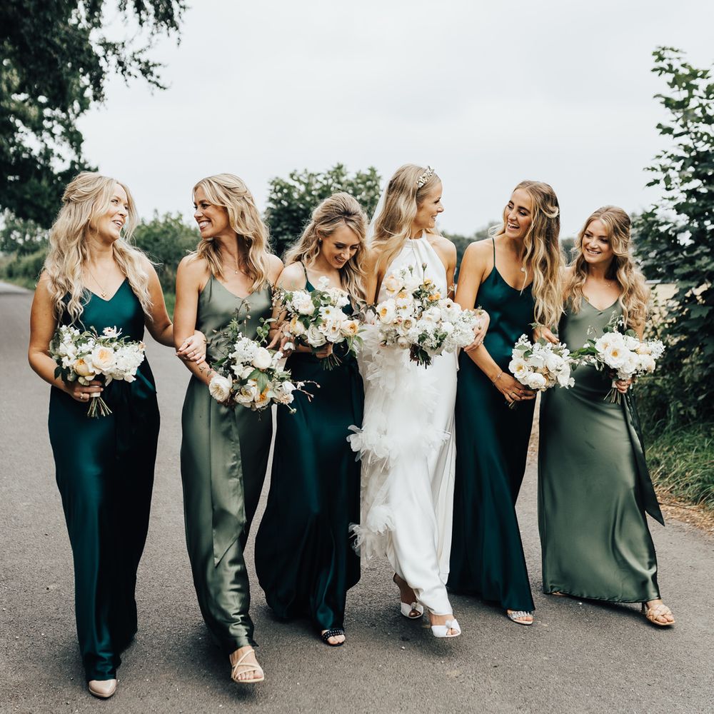 Bridal party with bridesmaids in different coloured green satin bridesmaid dresses by Rewritten 