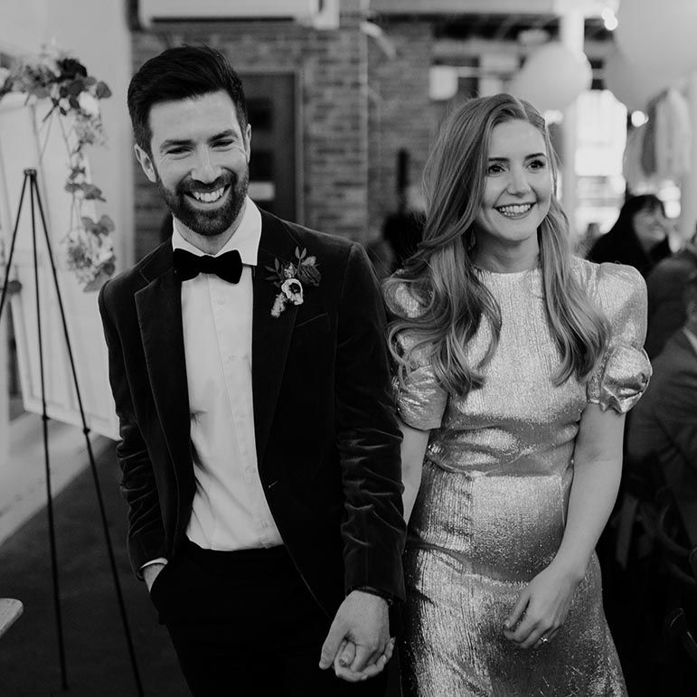 Bride and groom stroll into their wedding reception at 100 Barrington 