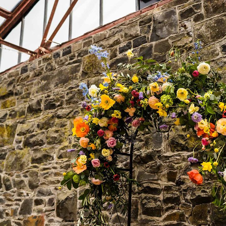Spring floral archway beside industrial brick wall 