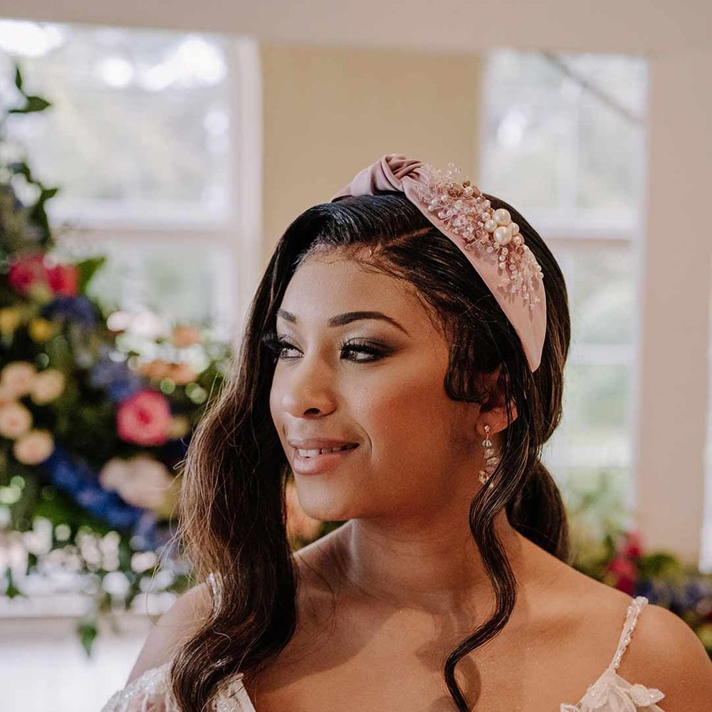 Bride in v-neck long sleeve shoulder cut out 3d appliqué wedding dress with flecks of gold wearing satin bridal headband 