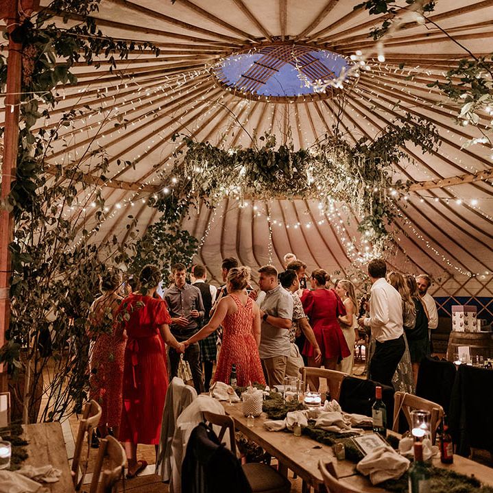 Fairy lights and foliage decorations in the yurt wedding reception at Camp Katur wedding in Yorkshire 