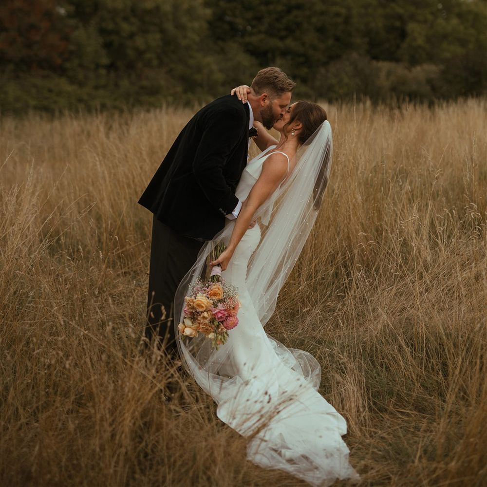 The bride and groom share a kiss in the field at The Pear Tree Purton 