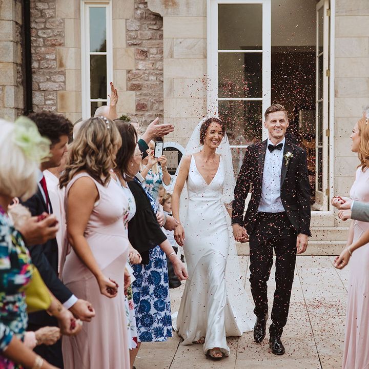 Confetti exit moment for the bride and groom at their traditional church ceremony 
