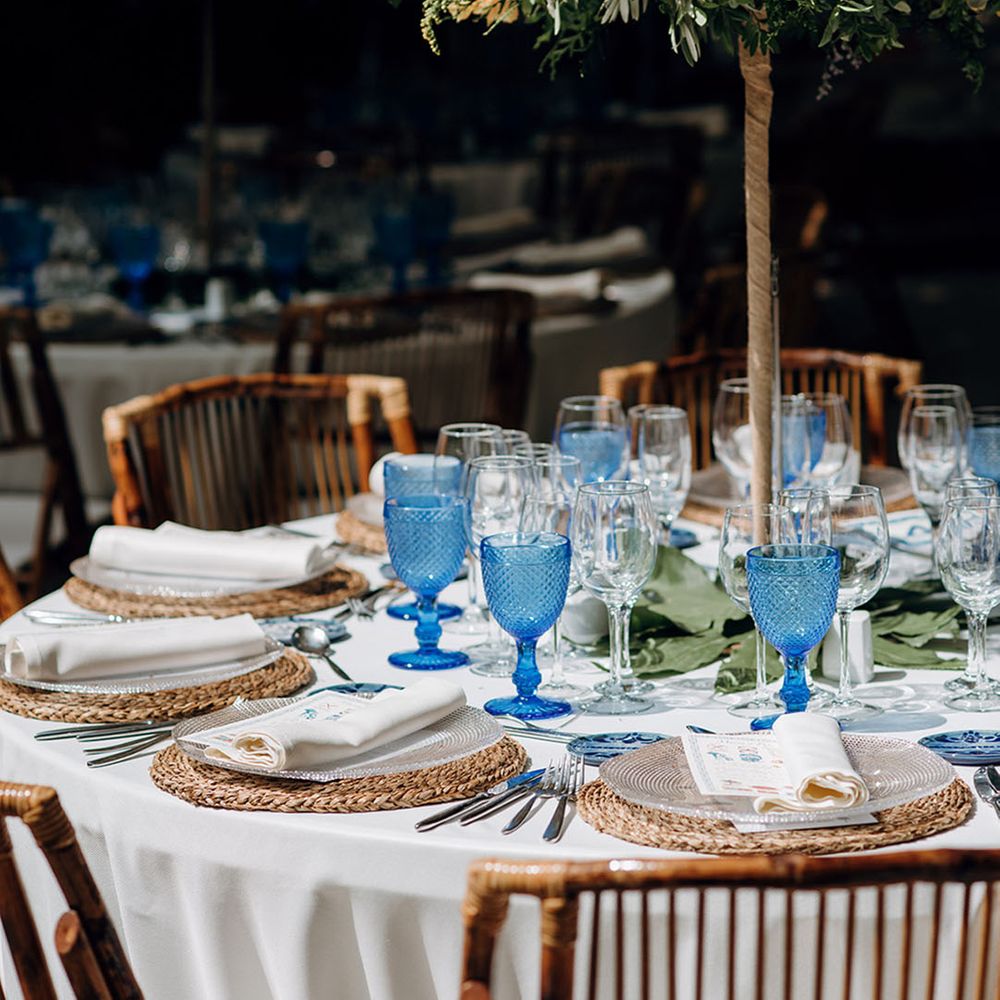 Round wedding tables with dark blue wedding glasses decorating the tablescape 