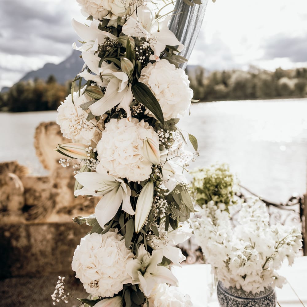 White lilies and hydrangea wedding flowers decorating the wooden framed altar 
