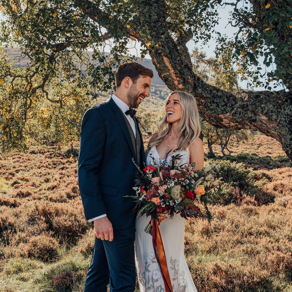 Bride & groom kiss in countryside at Woodland wedding