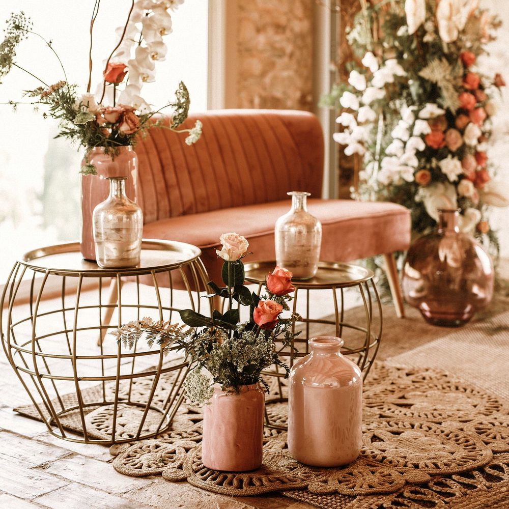 Seating area with pink velvet love seat, and gold wire tables 