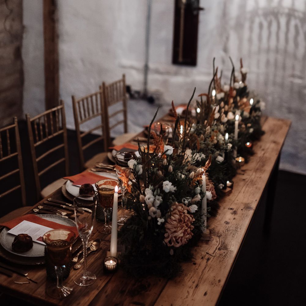 Romantic wedding reception lighting with chandelier installation and taper candles 
