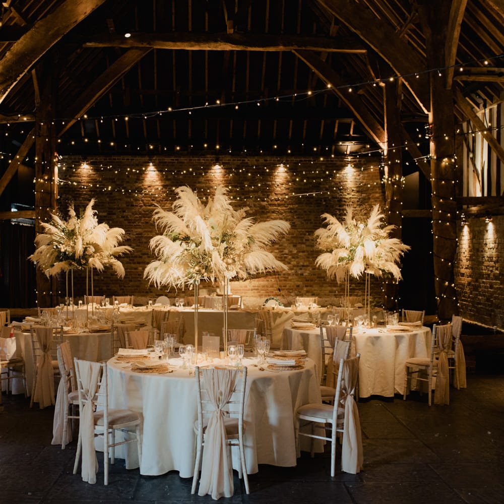 Intimate Cooling Castle Barn wedding reception decor with fairy lights, pampas grass centrepiece and acrylic signs 