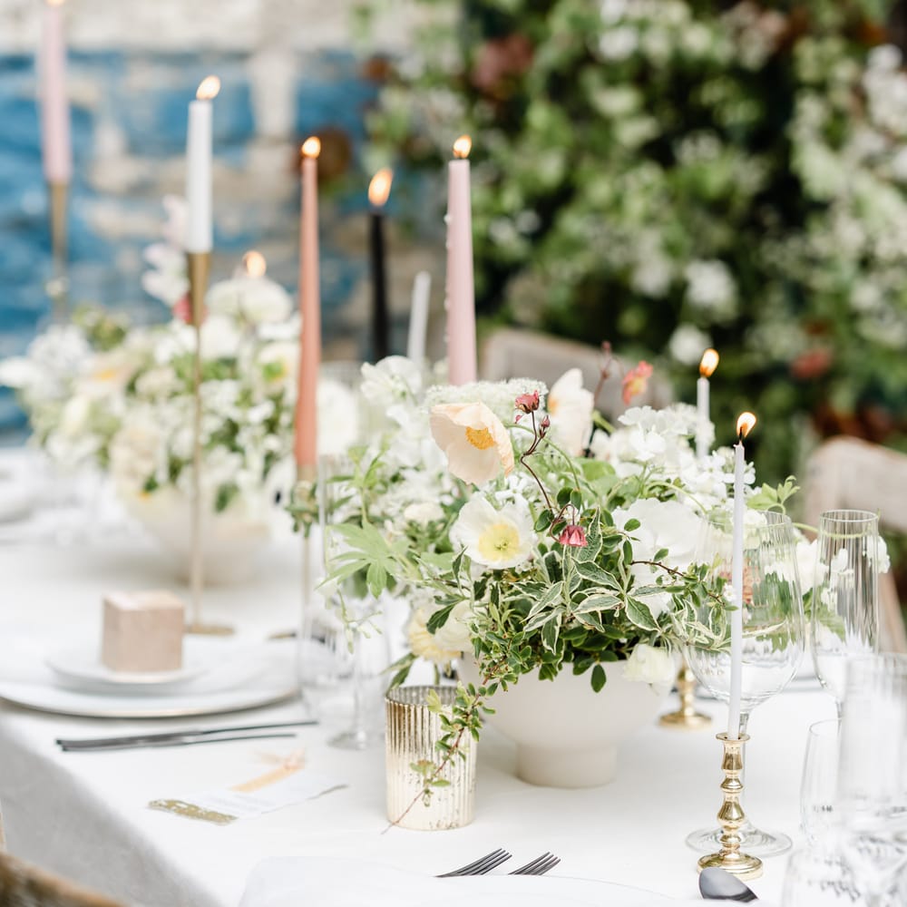 Elegant wedding table decor with taper candles, votives and romantic floral centrepiece 