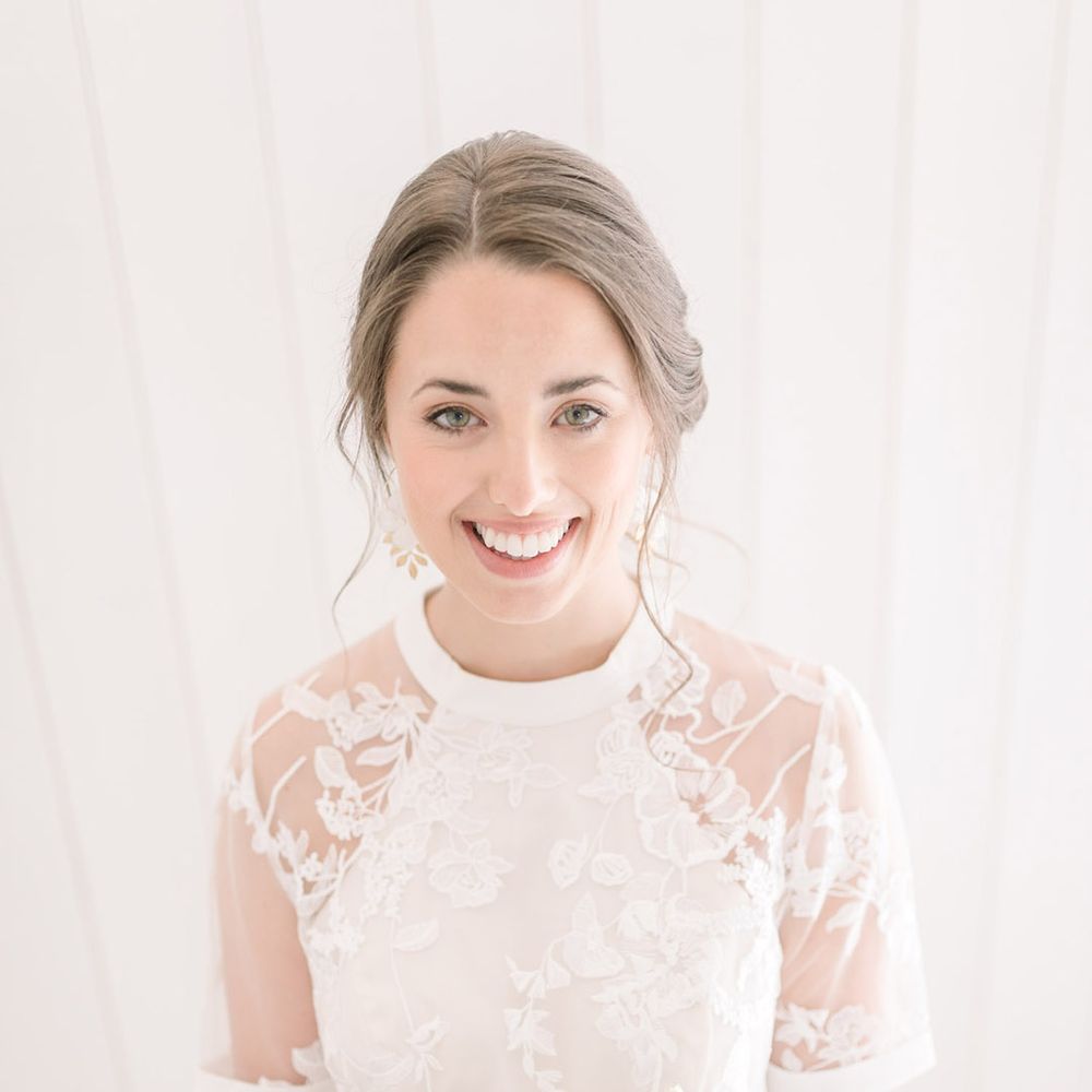 Beautiful bride with pinned up hair in a lace Phase Eight wedding dress holding a pastel flower bouquet 