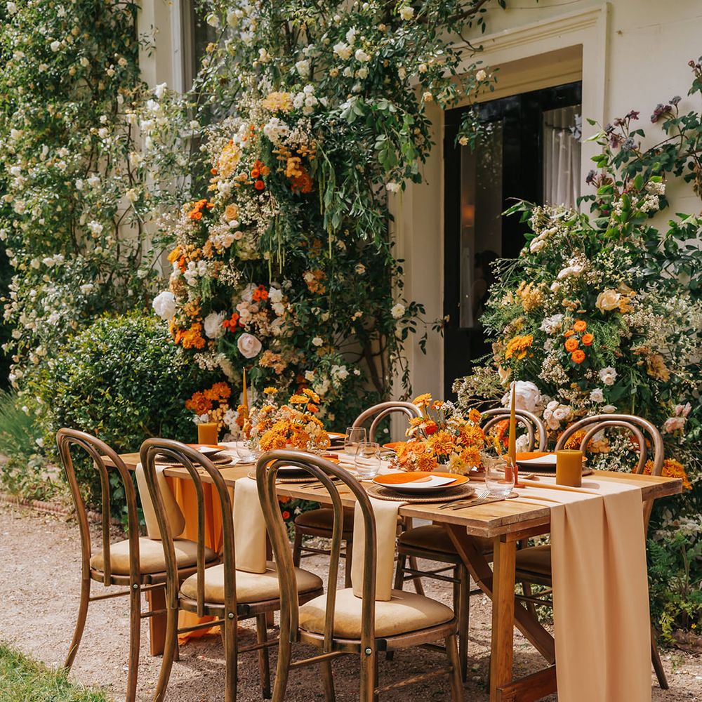 Outdoor wedding reception with orange flower, linen table cloth and table decor 
