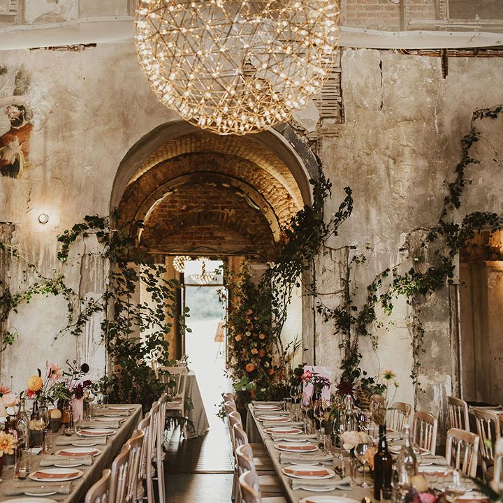 Rustic venue complete with floral vines climbing the walls and pastel florals along tables