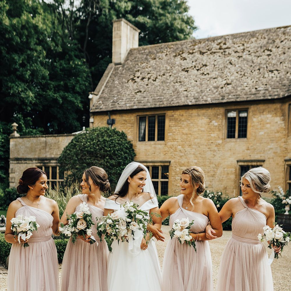 Bridal party in dusky pink bridesmaid dresses and bride in a Suzanne Neville wedding dress at Foxhill Manor luxury wedding venue 