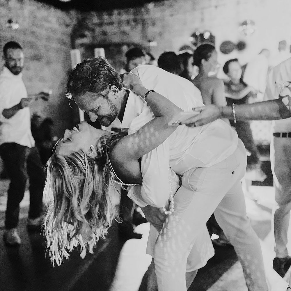 Groom leans the bride back as they dance for their wedding reception 