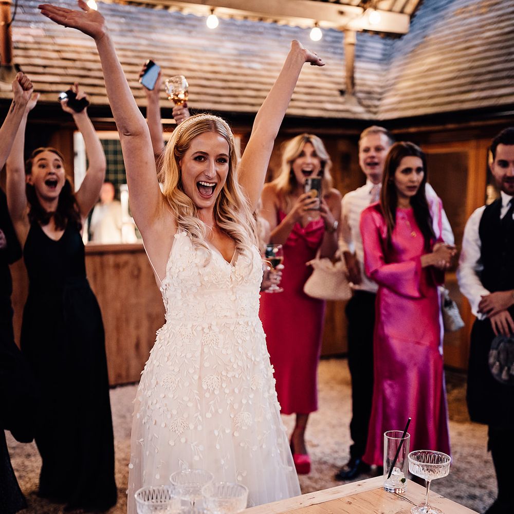 Bride wins the game of Prosecco pong they guests play for wedding entertainment 