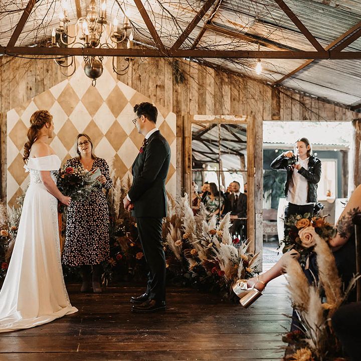 Bride & groom marry surrounded by dried floral arrangements at The Dreys wedding venue 