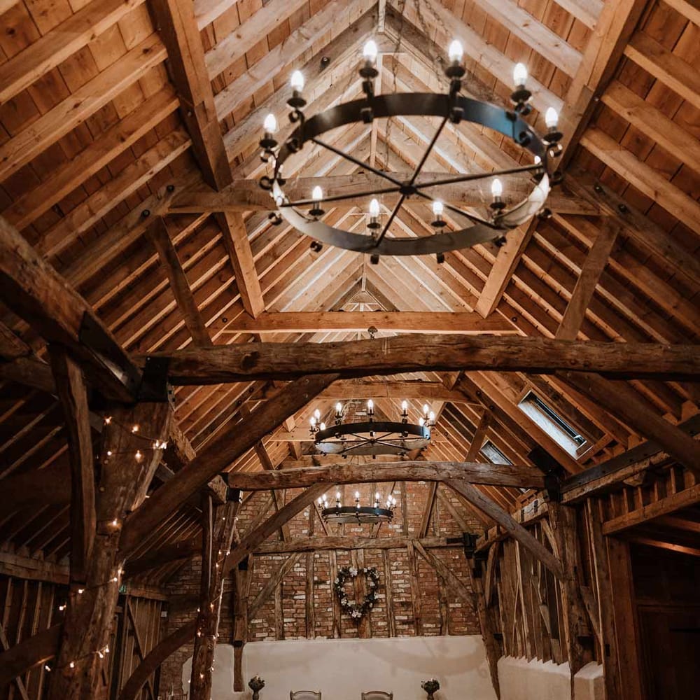 Bassmead Manor Barns wedding venue ceremony room with festoon lighting and fairy lights 