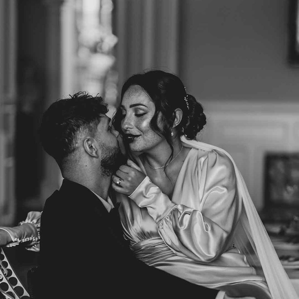 intimate couples portrait with interabled couple in a black tuxedo and satin wedding dress