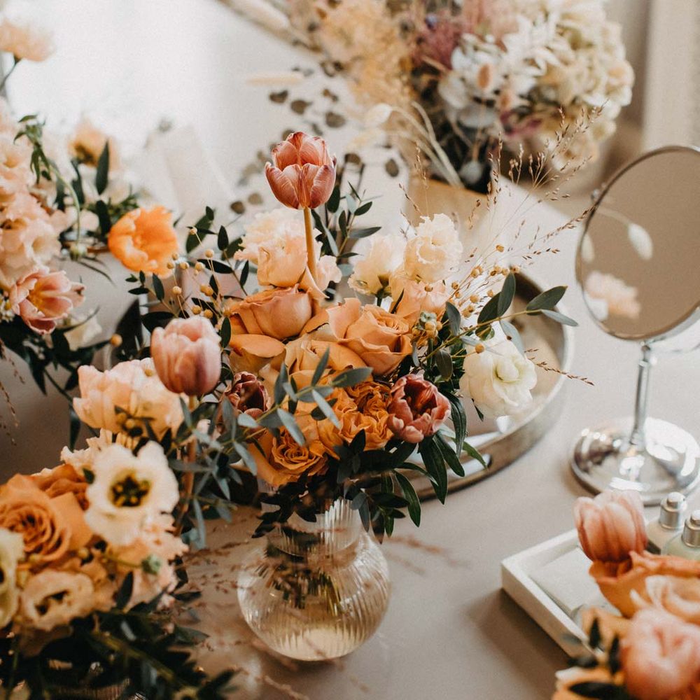 Blush and orange garden roses, poppies and carnations, dried flowers and eucalyptus wedding bouquets in glass vases 